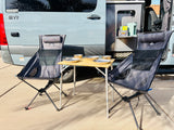 Perfect rv rental setup: portable camping chairs, table with bowls, and coffee/tea station next to the van.