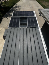 Overhead view of an RV rental roof featuring solar panels, an AC unit, and a durable composite deck for outdoor enjoyment.
