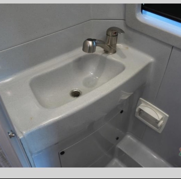  ready for your cooking needs on the road.|Compact refrigerator with wood-grain door in an RV rental interior — photo 7