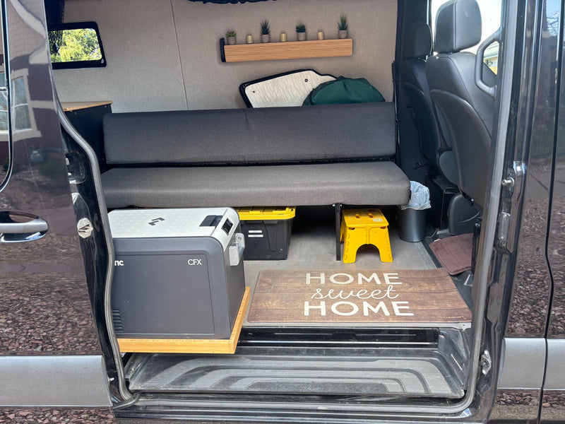  and decor shelf. Ideal for mobile van living adventures.|RV rental: Portable toilet stored on pull-out slide between custom black and wood cabinets — photo 3