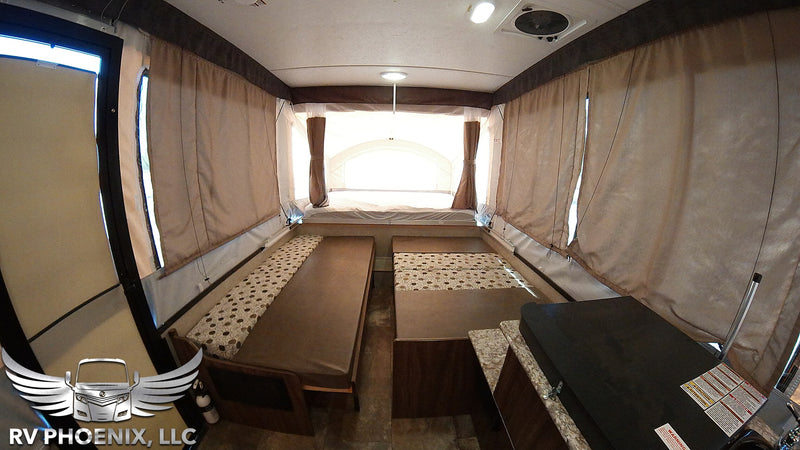 Spacious pop-up RV rental interior with beds, kitchen counter, and bright windows, perfect for camping. — photo 10