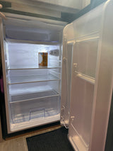 An RV rental's mini-fridge, open and clean, with clear shelves & a baking soda box. Ready for your groceries!