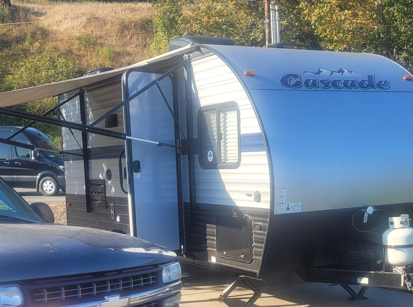 Experience outdoor adventures! This Cascade travel trailer RV rental, with an extended awning and propane tank, is ready for your trip.