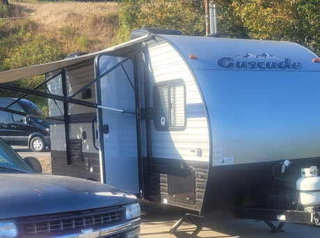Experience outdoor adventures! This Cascade travel trailer RV rental, with an extended awning and propane tank, is ready for your trip.