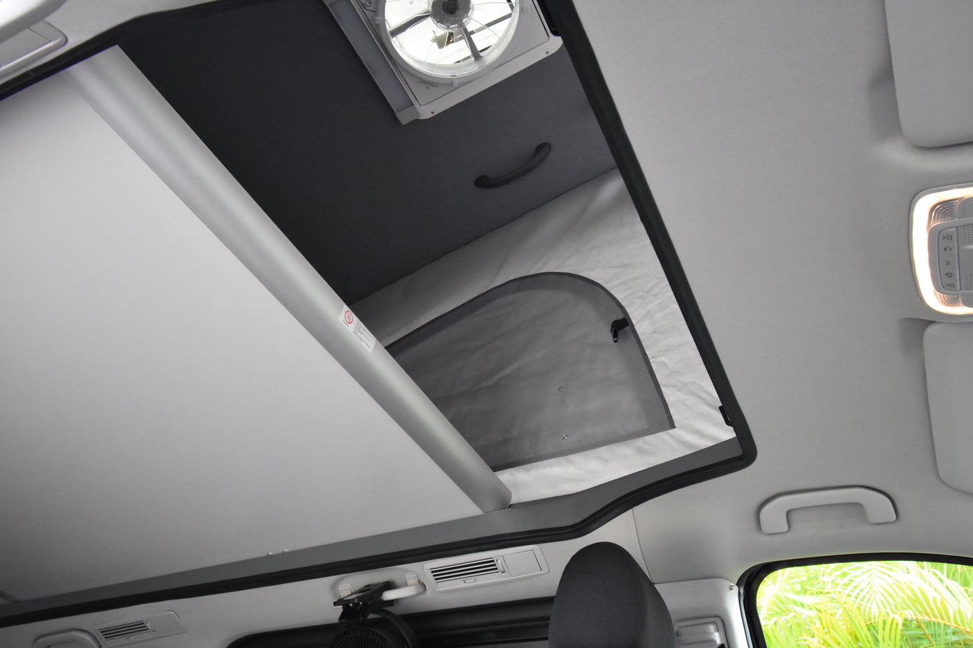 RV rental: Overhead view inside a pop-top camper, showing the ceiling fan and convertible sleeping area.