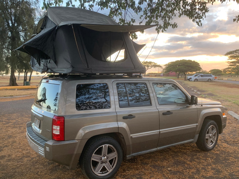 This RV rental, a Jeep Patriot SUV with a deployed rooftop tent, offers outdoor adventure at sunset. — photo 7