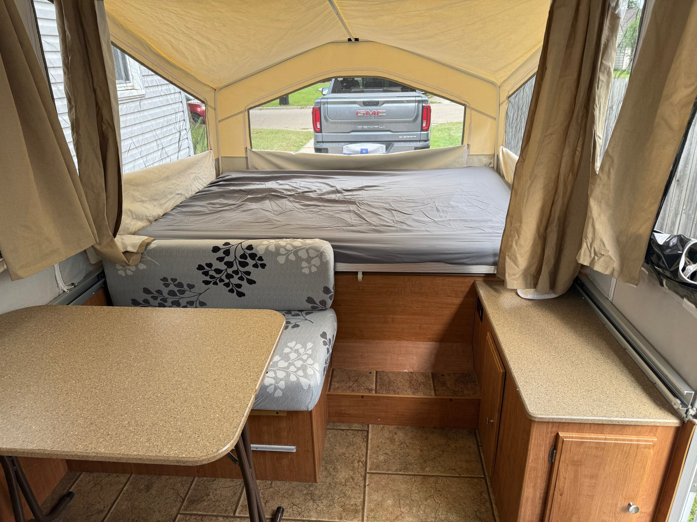  and floral cushions visible.|Cozy pop-up camper interior — photo 4