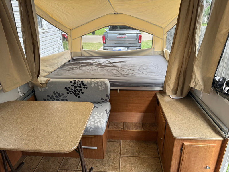  and floral cushions visible.|Cozy pop-up camper interior — photo 4