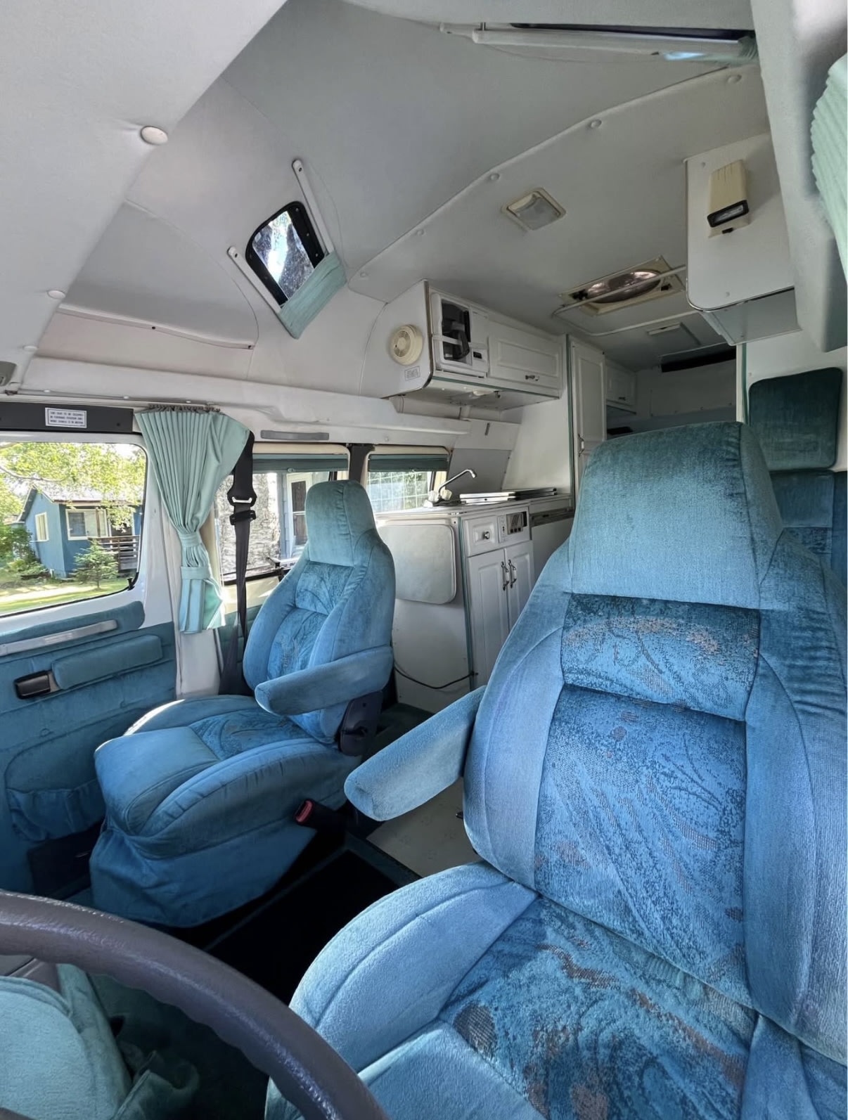  and built for exploring Alaska’s roads.|Anchorage Pickup Location – Convenient starting point for your Alaska adventure.|Low-Profile Camper Van – Maneuvers easily compared to large RVs while still offering cozy comfort.|Compact and Easy to Park – Fits into most standard parking spaces.|Spacious RV rental interior with blue seats — photo 5