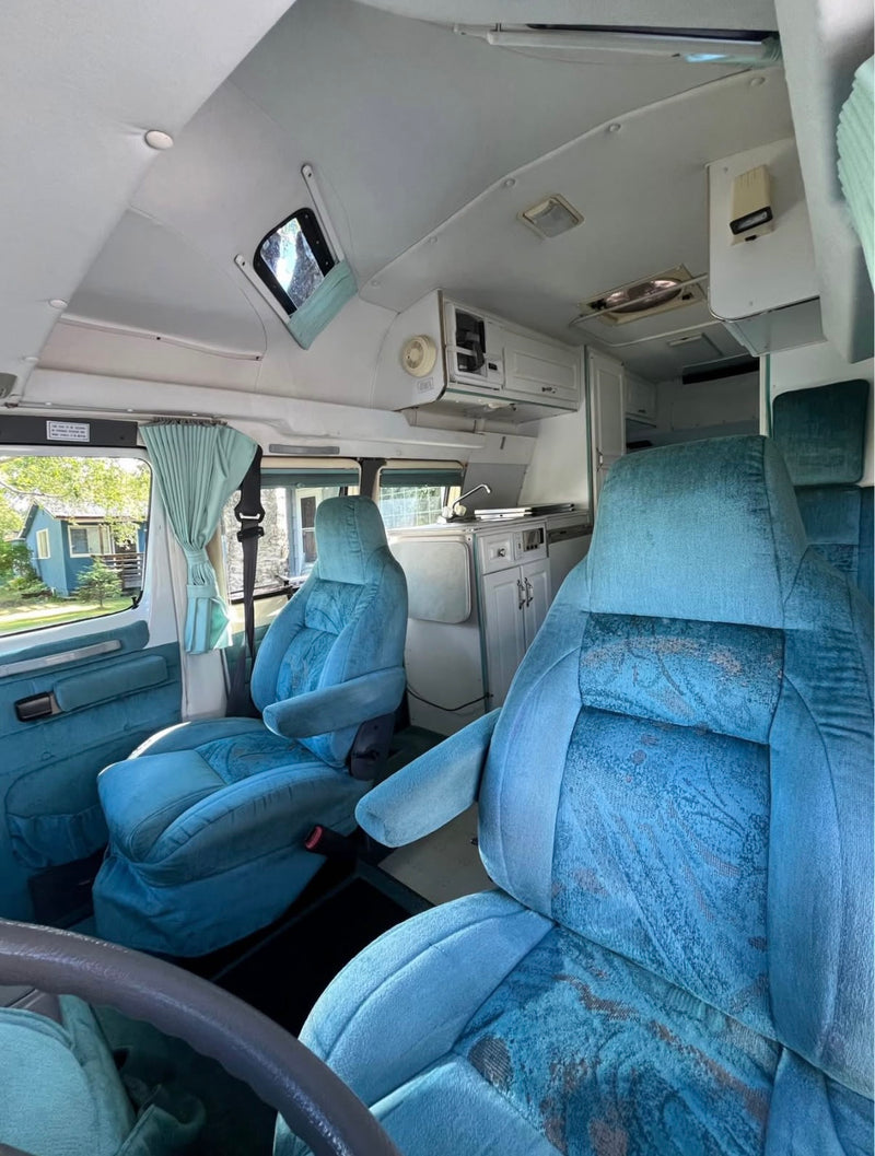  and built for exploring Alaska’s roads.|Anchorage Pickup Location – Convenient starting point for your Alaska adventure.|Low-Profile Camper Van – Maneuvers easily compared to large RVs while still offering cozy comfort.|Compact and Easy to Park – Fits into most standard parking spaces.|Spacious RV rental interior with blue seats — photo 5