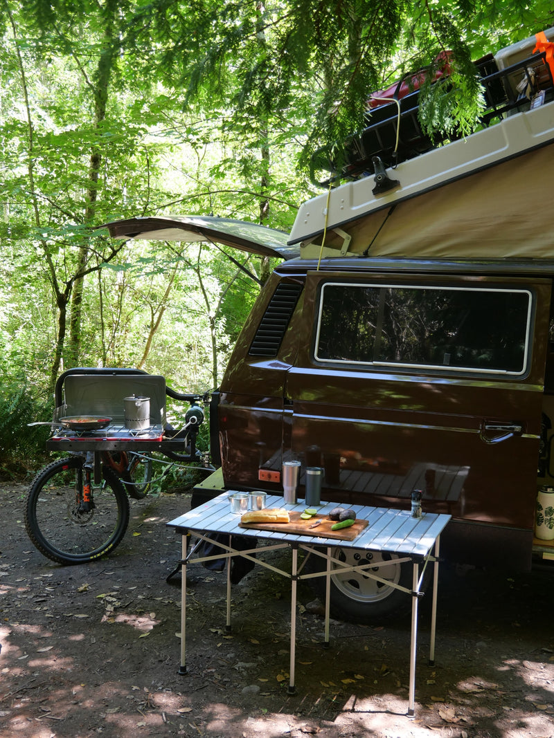  ready for adventure. Perfect RV rental for nature trips.|Outdoor cooking setup during an RV rental trip: a person by a stove — photo 6