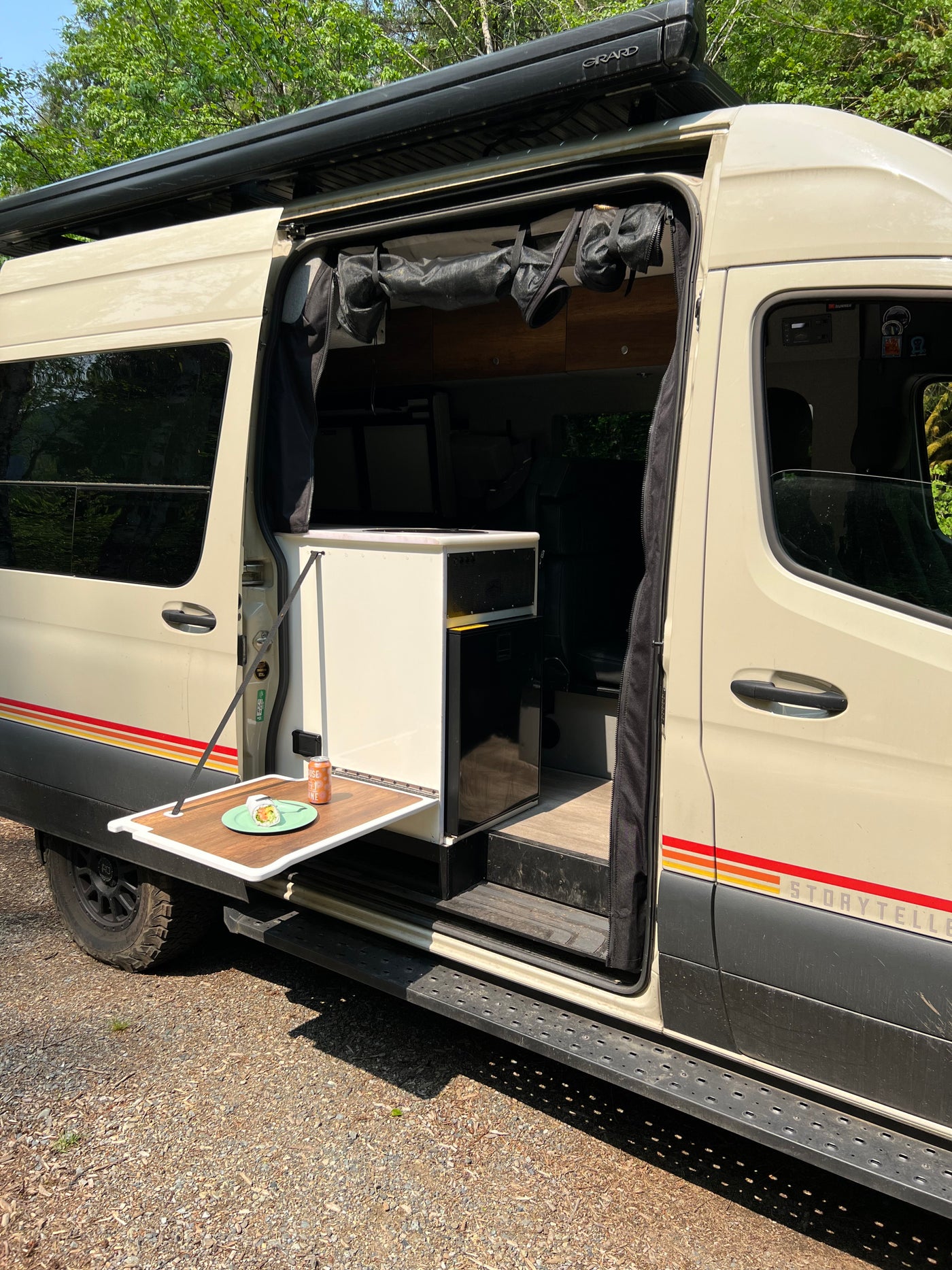 RV rental Storyteller camper van showcasing its convenient side table & interior. Ideal for road trips. — photo 10