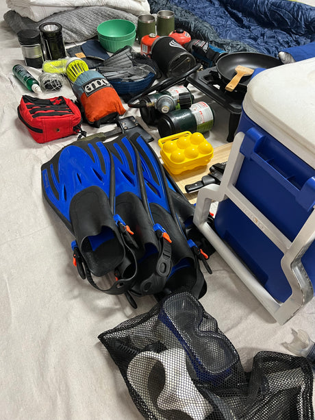 Packed for an RV rental trip: Snorkeling fins, camping stove, cooler, and other essential outdoor gear.