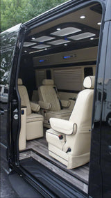 Step inside this premium RV rental: spacious interior, cream captain's chairs, wood-look floor, and custom ceiling lights.