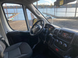 Interior of an RV rental van, looking out at a boat ramp with vehicles and docks extending into the water.