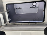 Inside an RV rental: Looking up into a spacious pop-top sleeping area with ladder access and integrated light.