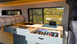This RV rental interior showcases a modern kitchen, cozy bed, and smart, organized storage solutions for your travels.