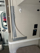 Gray duct tape temporarily secures a cabinet/door in an RV rental. Features a wall hook, USB/GFI outlets, and a "Never Walk Alone" sticker.