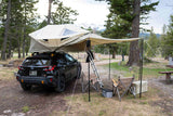 This Subaru, outfitted with a rooftop tent and awning, offers a unique car camping experience in a scenic campsite, a great RV rental alternative.