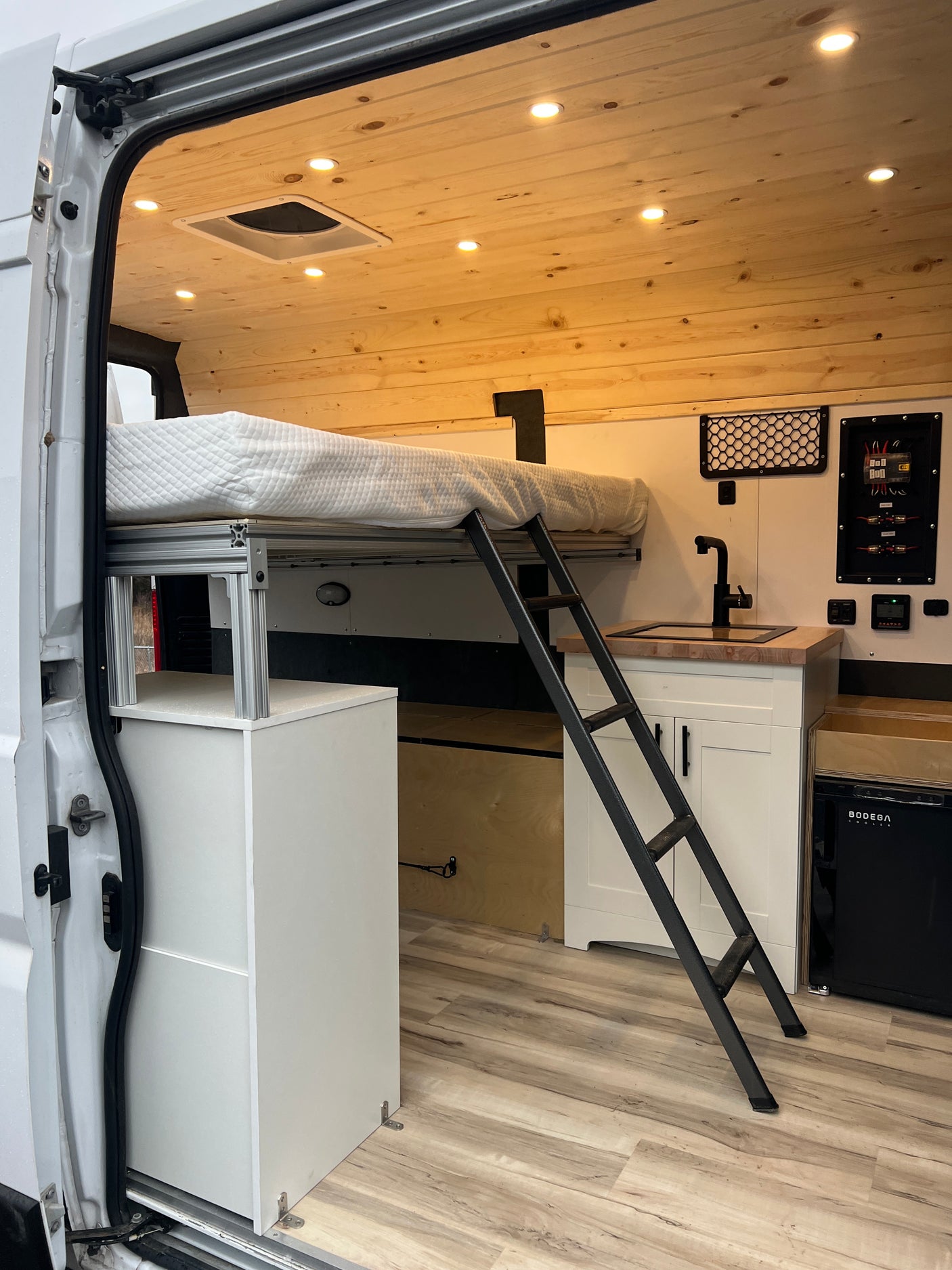 RV rental: Spacious camper van interior with raised bed, kitchen, and ample storage for comfortable mobile living.