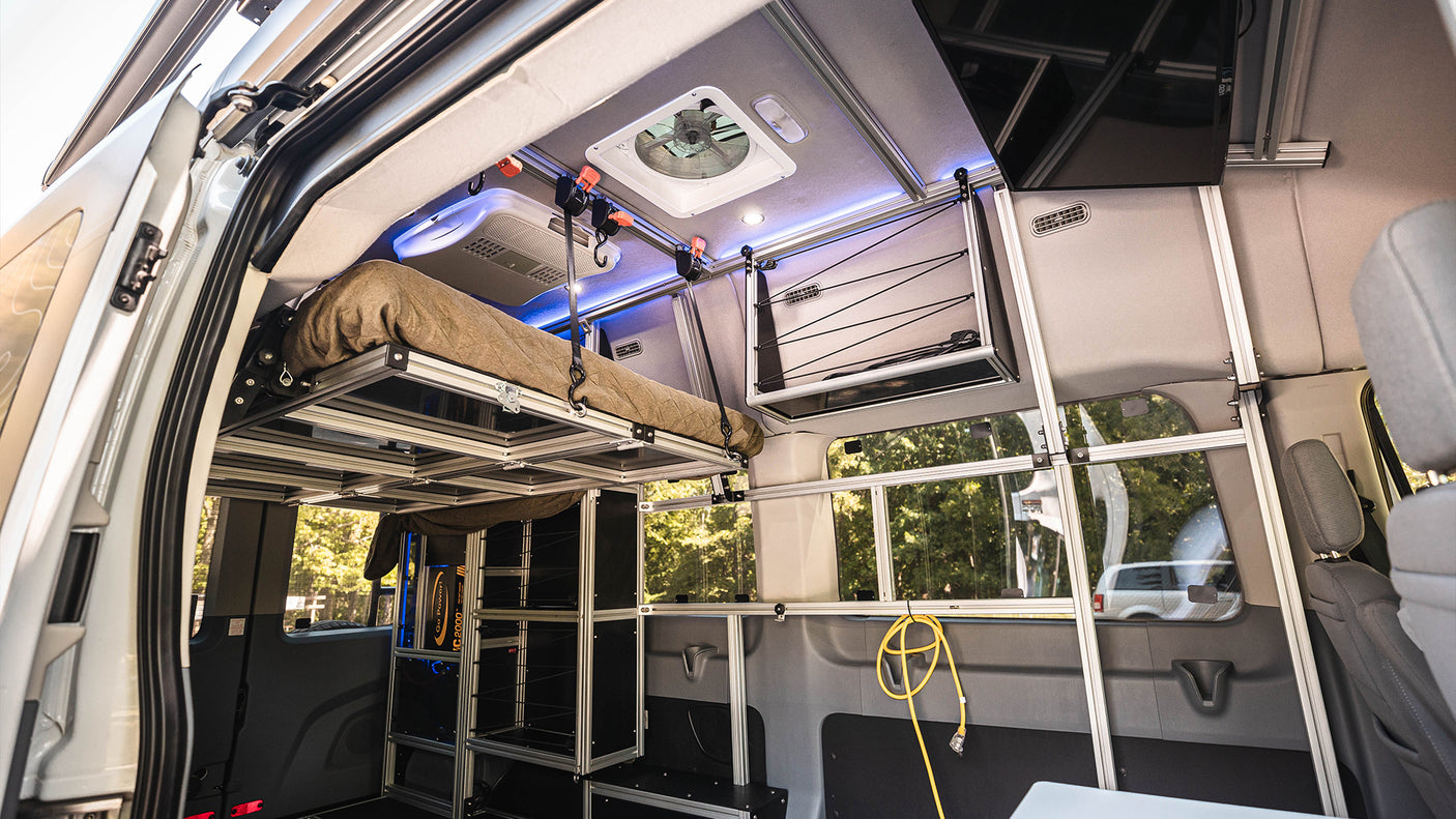 This RV rental's clever interior features a modular elevated bed and extensive aluminum storage for adventure.