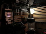 View of an RV rental interior at night, showing a glowing Dickinson heater, organized spice rack, and Alu-Cab storage.