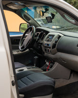 RV rental interior: driver's view of dashboard, steering wheel, and console with tech mounts. Ready for adventure.