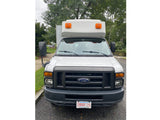 Front view of a white Ford box van, typical for commercial use or an RV rental. Massachusetts plate 2RBR 25 visible.