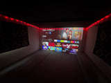 Cozy rv rental: a large projected screen displays streaming apps & movies under warm red string lights for entertainment.
