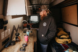 An RV rental's compact kitchen. A man makes coffee in his camper van, ready for the open road.