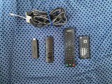 RV rental entertainment setup: HDMI cable, Fire TV Stick, and Jensen remotes for in-vehicle media streaming.