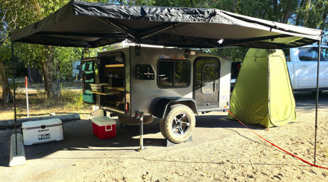 Explore the outdoors with this teardrop camper rv rental, featuring an outdoor kitchen, awning, and privacy tent.