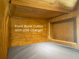 RV rental bunk bed interior: a wooden front cubby with a built-in USB charger, ideal for devices.