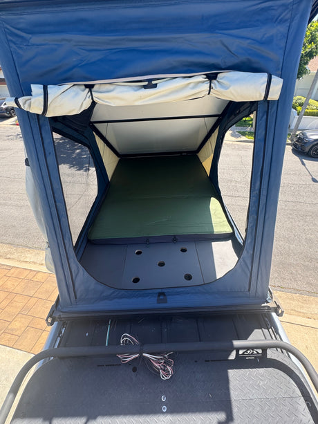 Spacious roof-top tent interior, ideal for your next RV rental adventure. Features a comfy mattress and airy design.