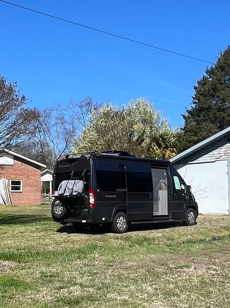  sliding door leads to front cockpit & seating.|Inside an RV rental: a compact wet bath featuring a toilet — photo 9