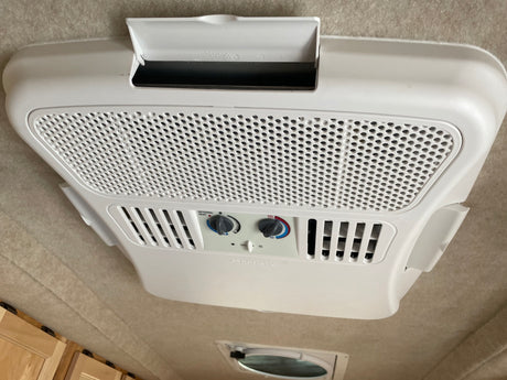 RV rental: Ceiling-mounted Dometic air conditioner unit showing fan speed and optional heat controls for comfort.