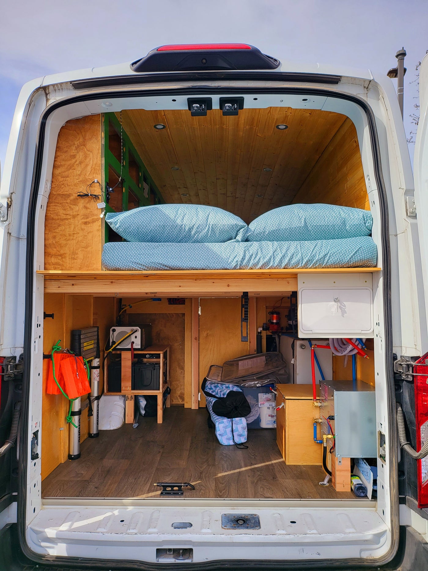  and custom wood paneling.|White Ford Transit high-roof van with all-terrain tires — photo 2