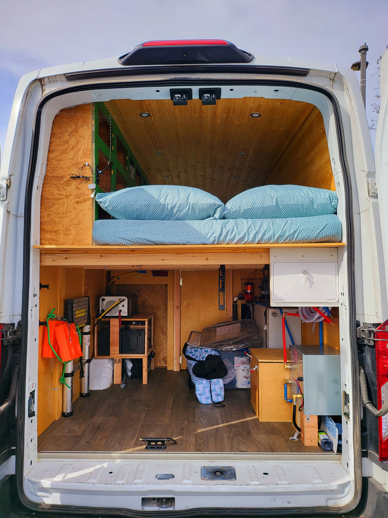  and custom wood paneling.|White Ford Transit high-roof van with all-terrain tires — photo 2