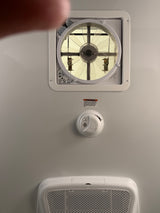 RV rental overhead: vent fan with controls, smoke alarm (with safety warning), and air return grill for comfort & safety.