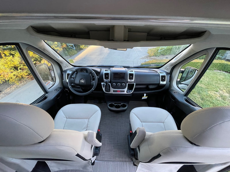 Step inside this spacious RV rental! Comfortable front cabin with driver and passenger seats, dashboard, and clear road view. — photo 6