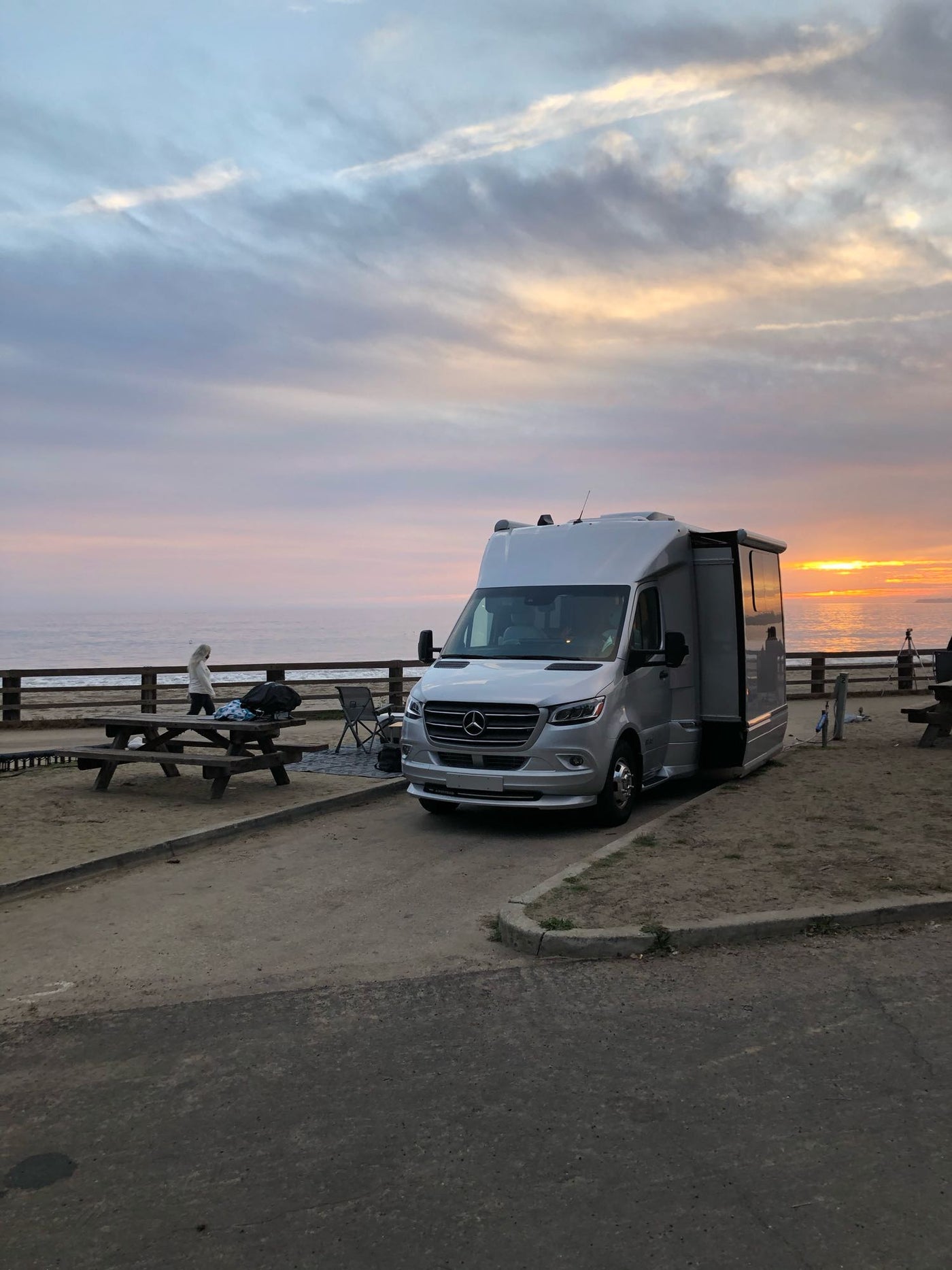  set up on a sandy campsite against a bluff.|Silver Airstream Atlas RV rental with extended awning — photo 15