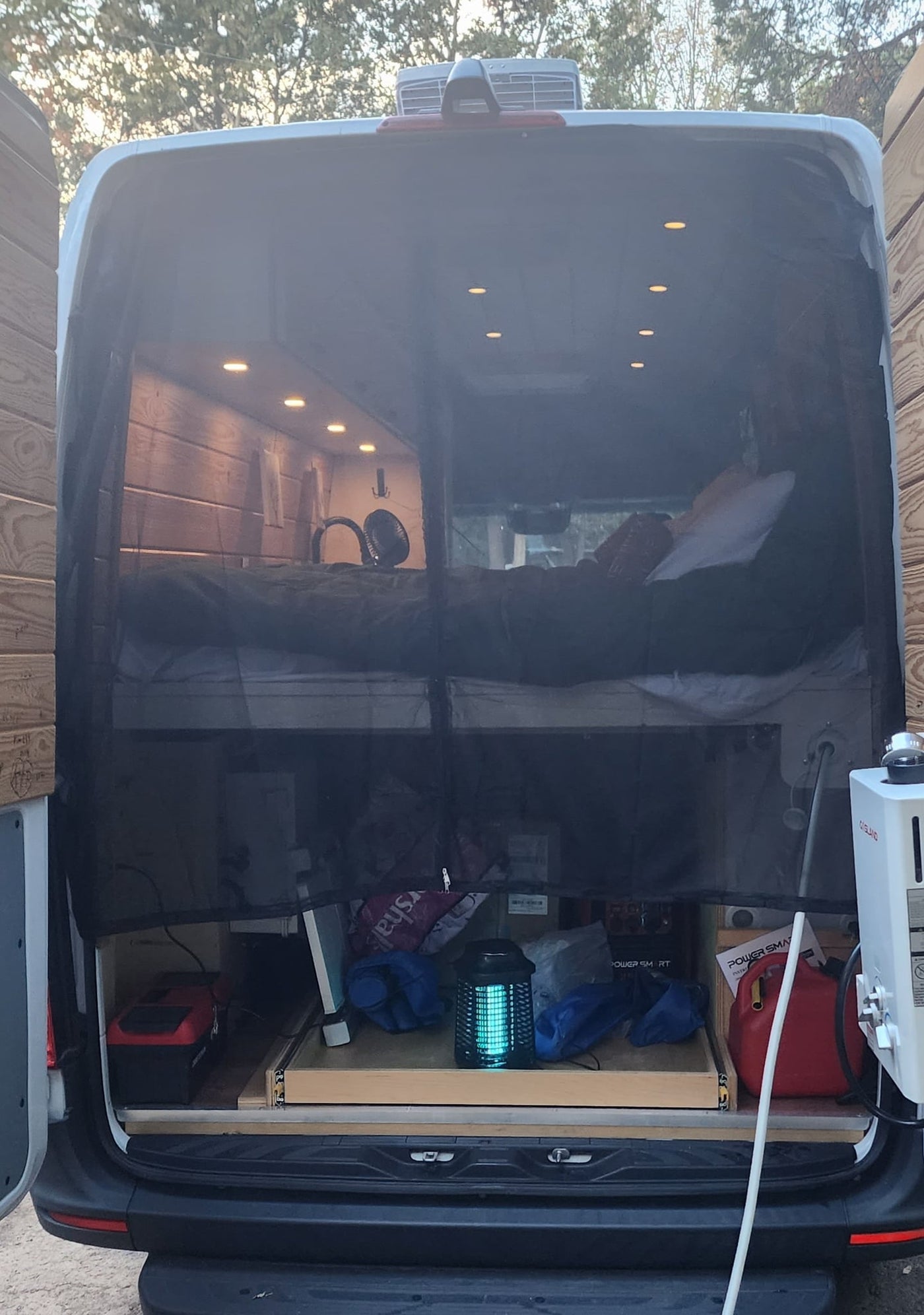 and unique decor of a camper van.|White rv rental campervan parked at a wooded campsite with picnic table — photo 5