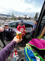 Ski trip crew with an RV rental, enjoying drinks in a snowy mountain village before hitting the slopes.