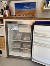 Inside an RV rental kitchen: a neatly organized fridge with labeled containers for condiments, veggies, and more, ideal for travel.
