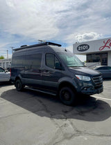 Dark grey custom Mercedes-Benz Sprinter van with off-road tires, perfect for your next rv rental adventure.