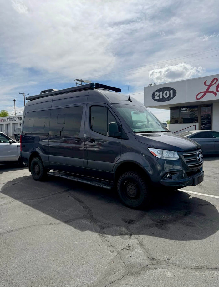 Dark grey custom Mercedes-Benz Sprinter van with off-road tires, perfect for your next rv rental adventure.