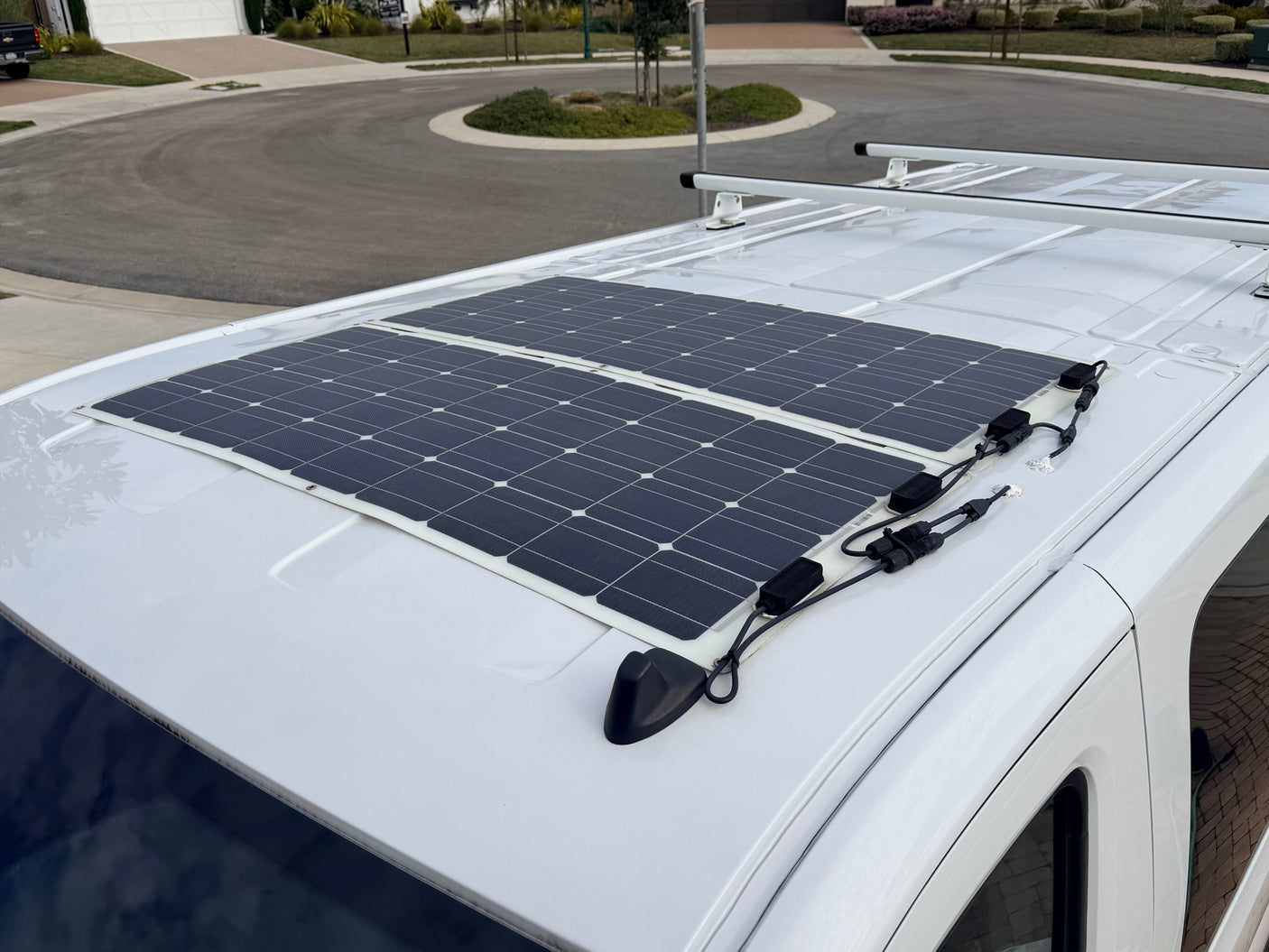 View of an RV rental roof with two flexible solar panels and wiring, providing off-grid power for adventures.