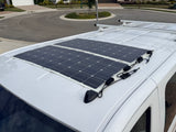 View of an RV rental roof with two flexible solar panels and wiring, providing off-grid power for adventures.