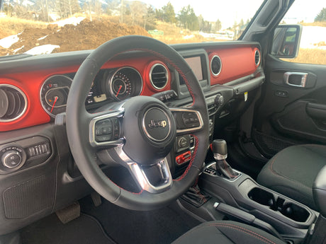 Inside a rugged Jeep with a red dashboard & advanced controls. Ideal vehicle for an outdoor RV rental journey.