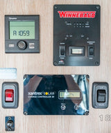 RV rental control panel: Truma thermostat, Winnebago main panel, Xantrex solar charge controller, water pump, generator, LP gas valve.
